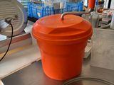 an orange bucket sitting on top of a metal counter