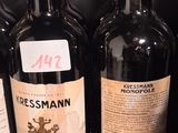 several bottles of red wine are lined up on a shelf