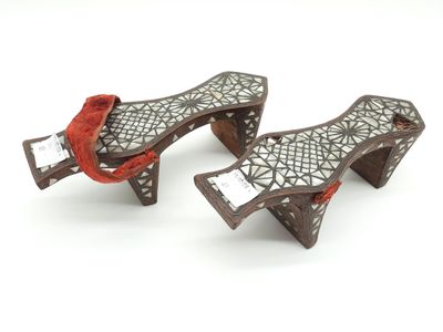 une paire de sabots en bois sculptés, ornés de lacets rouges