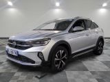 un SUV Volkswagen argenté garé sur un sol en carrelage à damier