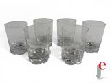six glasses are lined up in a row on a white surface