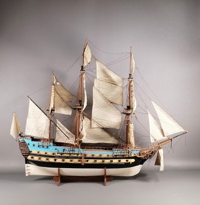 une maquette de voilier exposée sur une surface grise