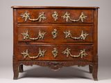 une commode ancienne avec des poignées en laiton