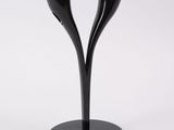 the black candle holder has two candles on it