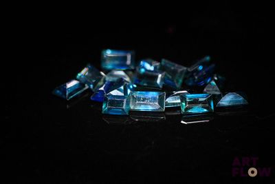 some very pretty blue glass pieces on a black surface