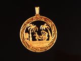 une image représentant un pendentif en or orné d'un bateau et de palmiers