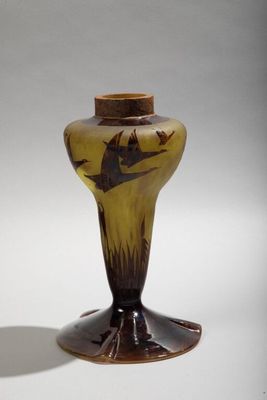 a brown vase with a bird on it on a white surface
