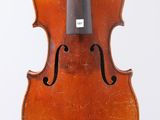un vieux violon posé sur une surface blanche