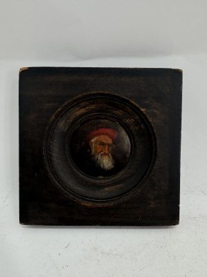 painting of an old man with a beard and a red hat in a black frame