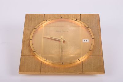 une horloge en bois avec un cadran doré sur un fond blanc