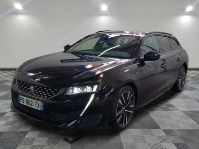 la voiture noire est garée sur un sol en damier dans le garage