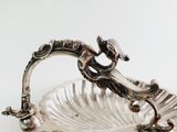 a silver plate with a dragon on it on a table