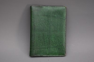 un portefeuille en cuir vert posé sur une table
