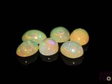 un groupe de perles oplites blanches posées sur une surface noire