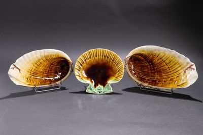trois plats en forme de coquillage sont posés sur une table