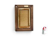 an old picture frame hanging on a wall with a small piece of wood