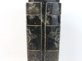 a black vase with a pattern on it sitting on a table