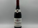 la bouteille de vin rouge est posée sur une surface blanche