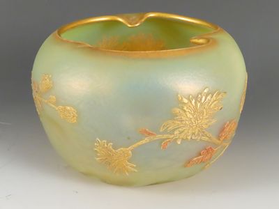 un vase vert orné d'un motif doré