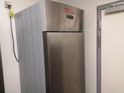 a stainless steel refrigerator in the corner of a room
