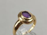 a gold ring with a purple stone on top of it