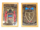 deux plaques fixées au mur d'un immeuble et ornées d'un blason