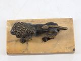 an image of a bronze lion statue on a marble block