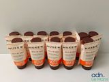 six tubes de crème solaire Nuxe posés sur une table