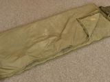a sleeping bag on the floor next to a pair of scissors