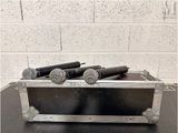 three microphones in a metal case on a table