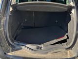 the back of a car with its trunk open on gravel ground