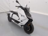 une moto blanche garée dans une pièce aux murs blancs