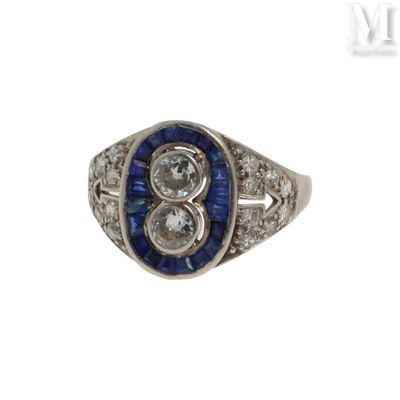 une photo d'une bague sertie d'un diamant et d'un saphir, en or blanc 18 carats