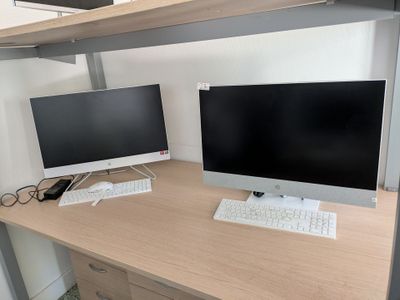 two computer monitors and a keyboard on a desk