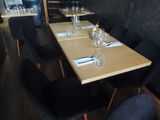 a wooden table with black chairs and place settings on it
