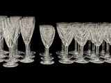 douze verres à vin en cristal alignés sur un fond noir