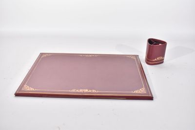 une photo d'un sous-main en cuir sur lequel se trouvent un stylo et une tasse