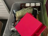 a plastic container filled with assorted items on the floor
