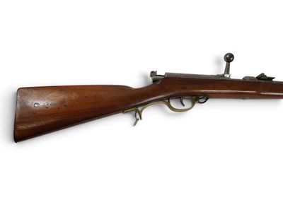 un vieux fusil avec un canon en bois et des garnitures en laiton