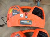 an orange and black blower sitting on top of a floor next to a hose