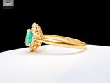 a close up of a gold ring with a green stone in it