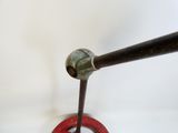 a metal pipe with a red ring and a black handle