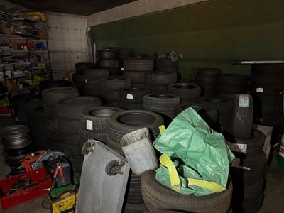 a lot of tires that are stacked up in a garage