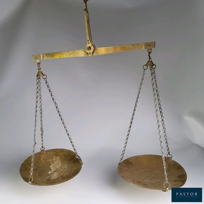 a gold scale with chains hanging from it ' s sides