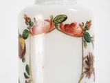 a white glass jar with a floral design on it
