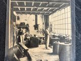 an old black and white photo of a man working in a factory