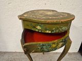 a small wooden table with a red cushion underneath it