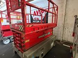 the red sciom is parked in a warehouse with a sign on the wall