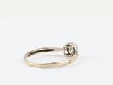 a close up of a diamond ring on a white surface