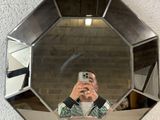 mirrored mirror with a man taking a picture of himself in it